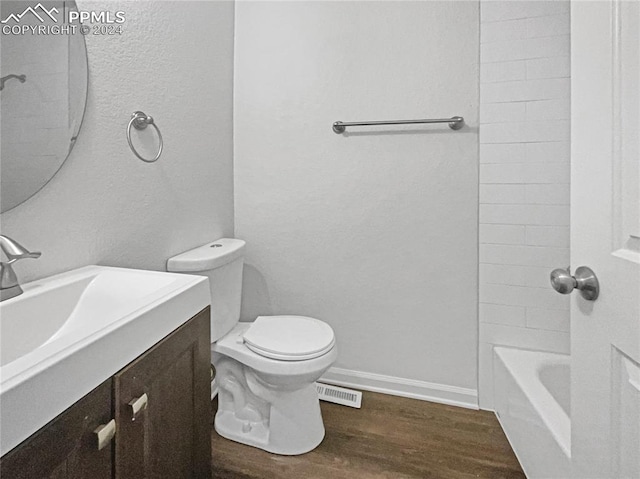 full bathroom with toilet, tiled shower / bath combo, vanity, and hardwood / wood-style flooring