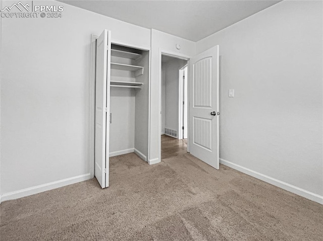 unfurnished bedroom with a closet and carpet floors