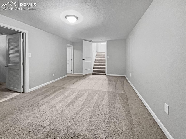 empty room with carpet floors and a textured ceiling