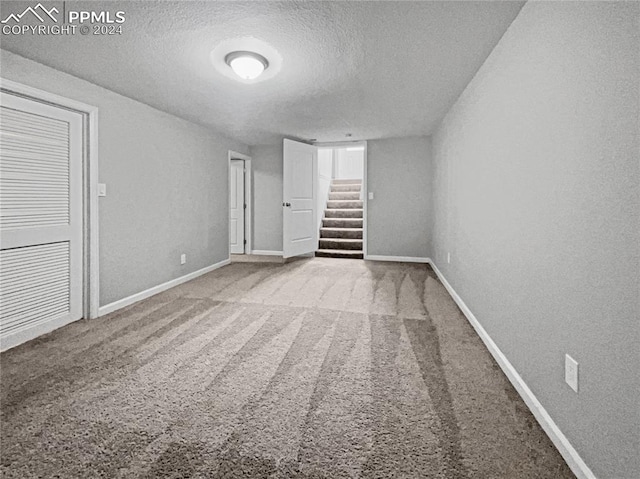 carpeted spare room featuring a textured ceiling