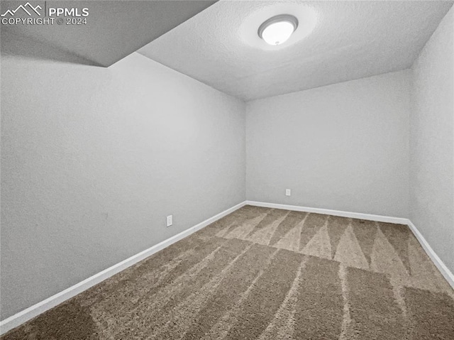 carpeted spare room with a textured ceiling