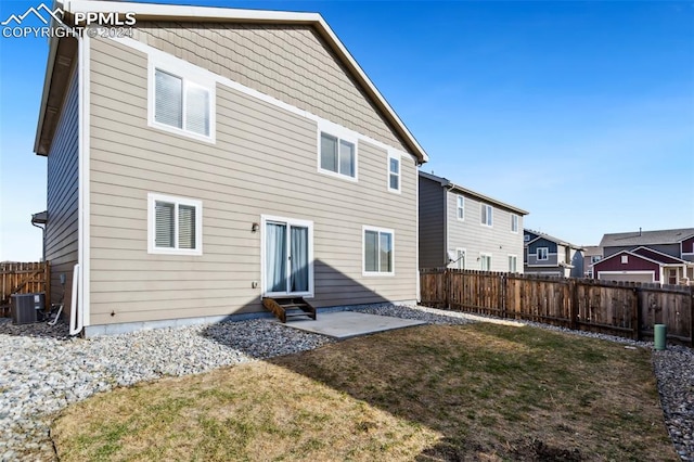 rear view of house with a yard, a patio, and cooling unit