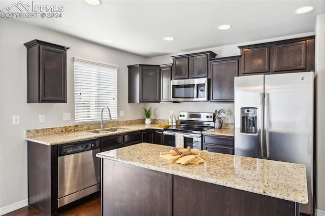 kitchen featuring light stone countertops, sink, a center island, dark hardwood / wood-style floors, and appliances with stainless steel finishes