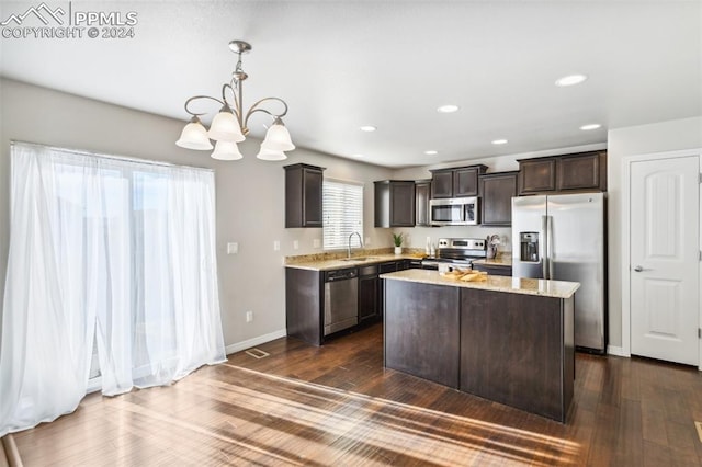 kitchen with dark brown cabinetry, stainless steel appliances, dark hardwood / wood-style floors, pendant lighting, and a kitchen island