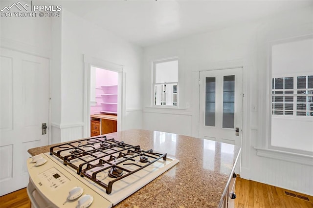 kitchen featuring white stove, light stone countertops, and light hardwood / wood-style floors