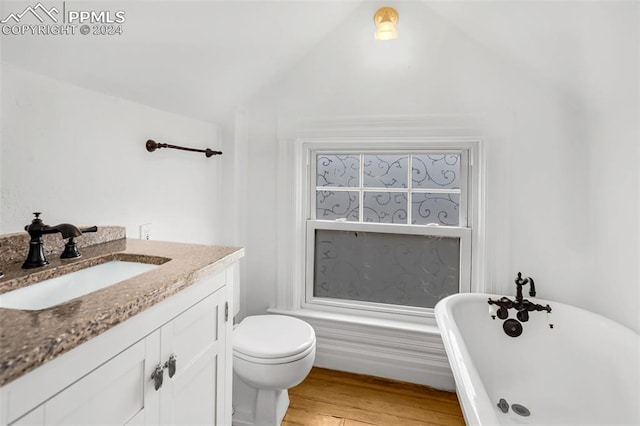 bathroom with vanity, vaulted ceiling, a tub, and wood-type flooring