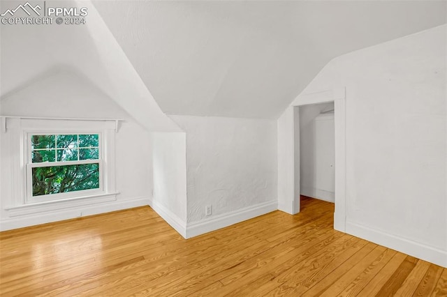 bonus room featuring light wood-type flooring and lofted ceiling