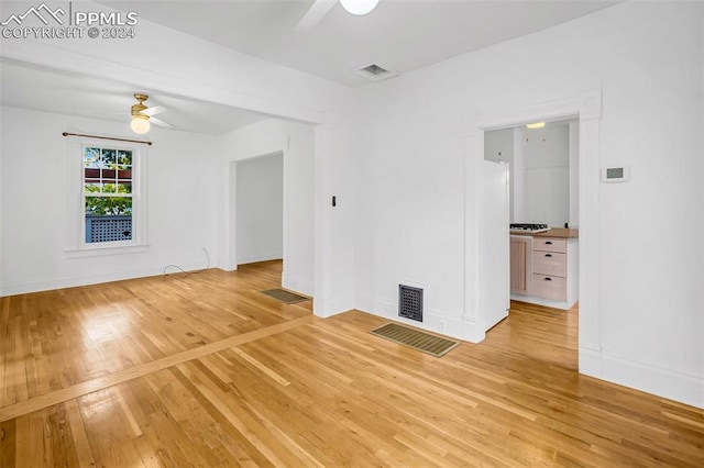 empty room with ceiling fan and light wood-type flooring