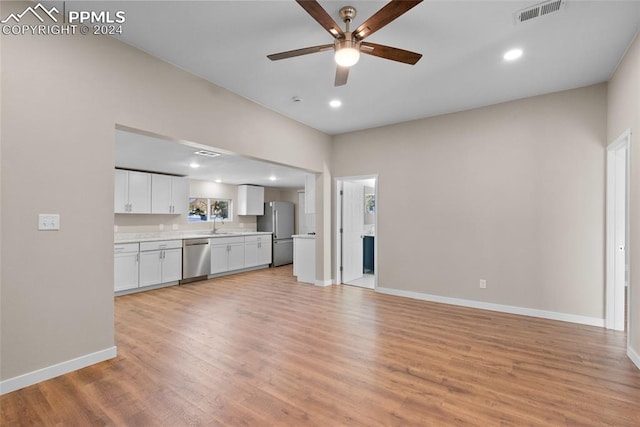 unfurnished living room with ceiling fan, light hardwood / wood-style flooring, and sink