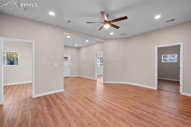 unfurnished room featuring a healthy amount of sunlight, ceiling fan, and light hardwood / wood-style floors