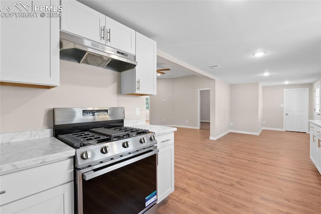 kitchen with light stone countertops, ceiling fan, stainless steel gas range oven, light hardwood / wood-style floors, and white cabinets