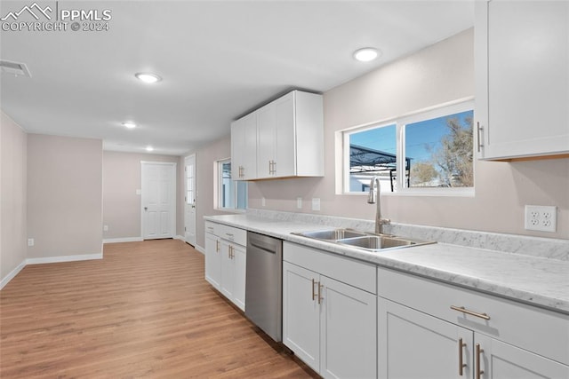 kitchen with light stone countertops, white cabinetry, dishwasher, sink, and light wood-type flooring