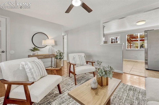 sitting room featuring a textured ceiling, light hardwood / wood-style floors, and ceiling fan