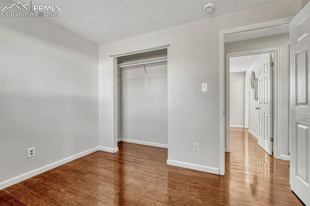 unfurnished bedroom featuring hardwood / wood-style floors and a textured ceiling