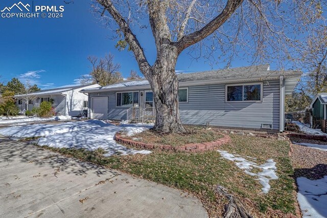 1511 N Chelton Rd, Colorado Springs, CO 80909 - snow covered rear of property featuring a garage and concrete driveway