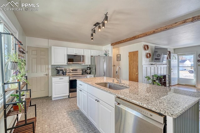 1511 N Chelton Rd, Colorado Springs, CO 80909 - kitchen with stainless steel appliances, a sink, white cabinets, and a center island with sink