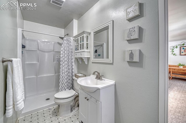 bathroom with curtained shower, vanity, and toilet