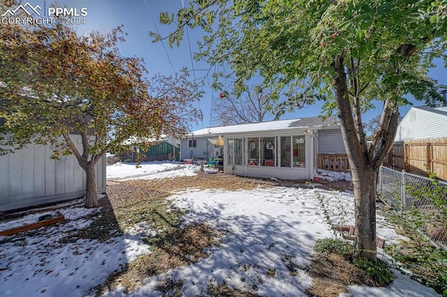 snow covered house with a sunroom