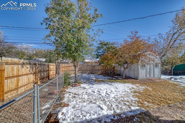 1511 N Chelton Rd, Colorado Springs, CO 80909 - yard layered in snow featuring a fenced backyard and an outbuilding