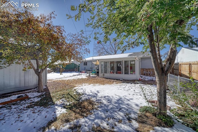 1511 N Chelton Rd, Colorado Springs, CO 80909 - snow covered rear of property with a sunroom and a fenced backyard