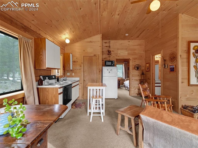 kitchen featuring white cabinets, plenty of natural light, white fridge, and lofted ceiling