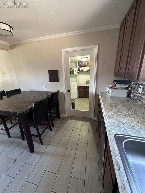 dining area featuring ornamental molding, sink, and washer / clothes dryer