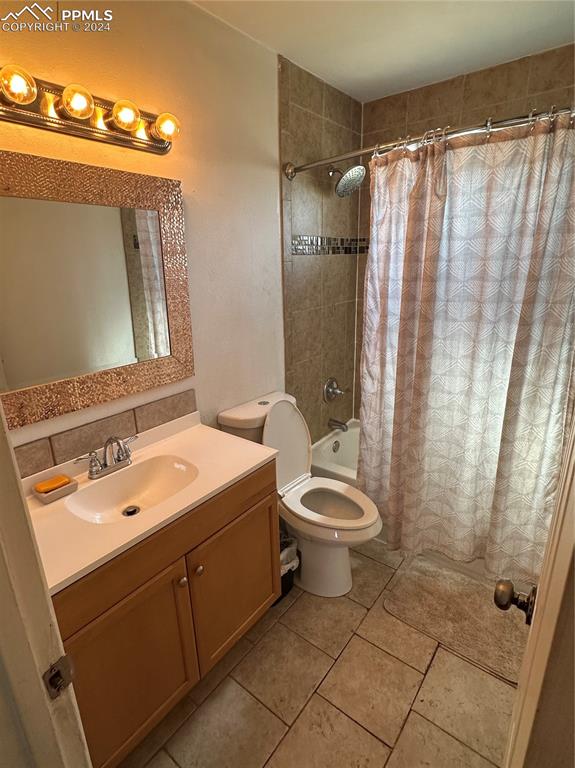 full bathroom featuring tile patterned flooring, vanity, shower / bath combination with curtain, and toilet