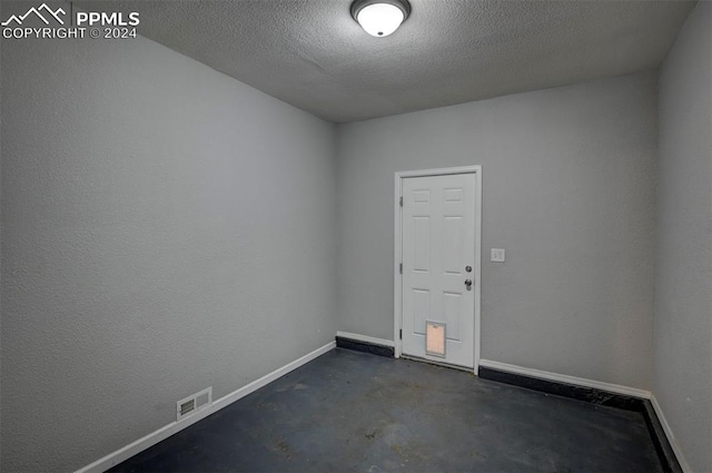 spare room with a textured ceiling