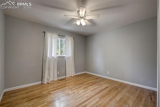 empty room featuring ceiling fan and light hardwood / wood-style flooring