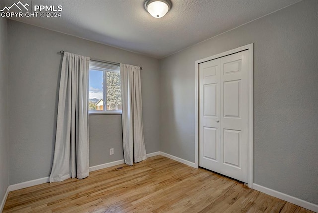 unfurnished bedroom with a closet and light hardwood / wood-style flooring