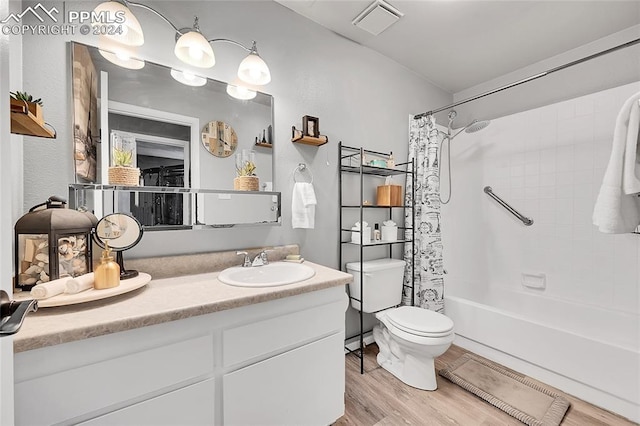 full bathroom featuring toilet, vanity, hardwood / wood-style flooring, and shower / tub combo with curtain