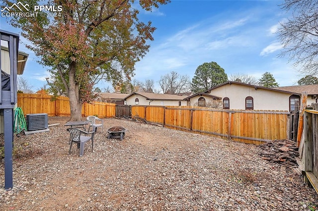 view of yard with a fire pit and cooling unit