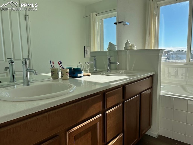 bathroom with vanity and a relaxing tiled tub