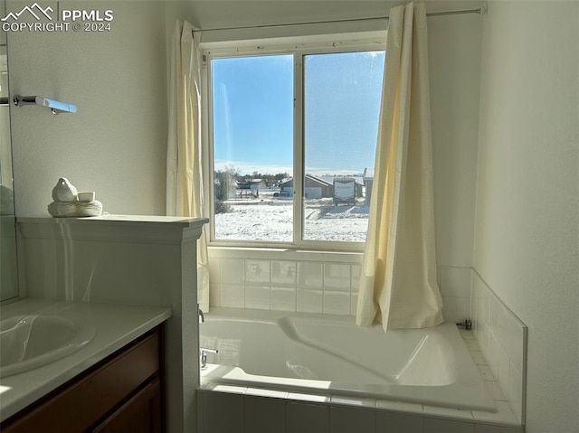 bathroom with tiled bath and vanity