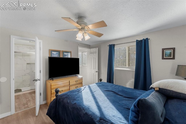 bedroom with a textured ceiling, hardwood / wood-style flooring, ceiling fan, and connected bathroom