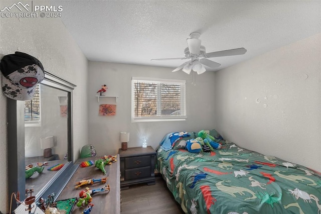 bedroom featuring hardwood / wood-style flooring, ceiling fan, and a textured ceiling