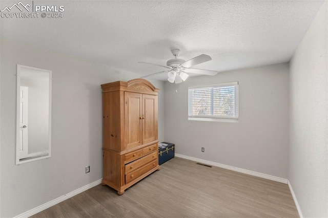 bedroom featuring ceiling fan, a textured ceiling, and light hardwood / wood-style flooring