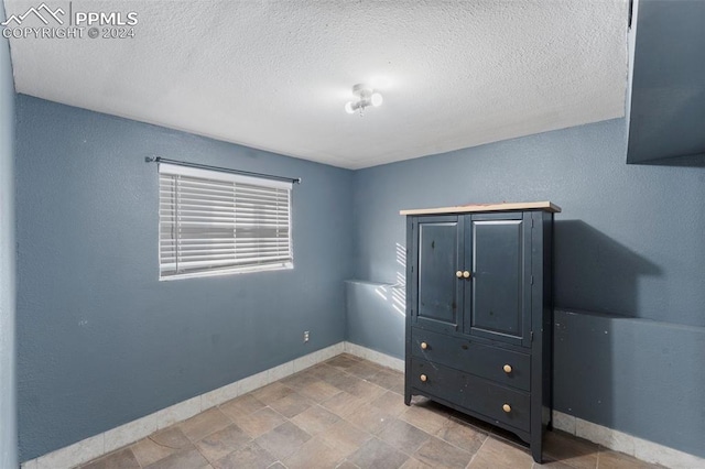 unfurnished bedroom with a textured ceiling