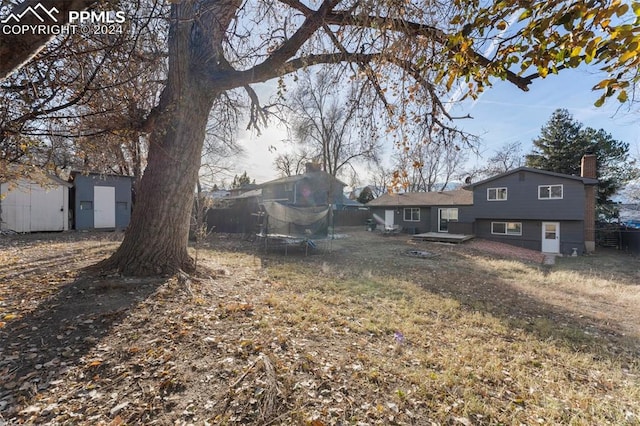 view of yard with a trampoline and a shed