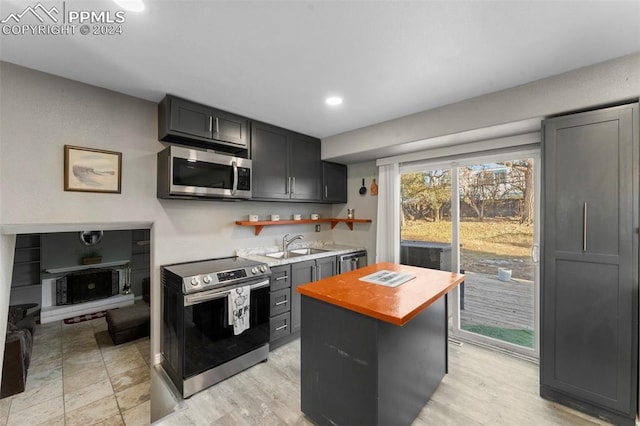 kitchen featuring appliances with stainless steel finishes, a center island, and sink