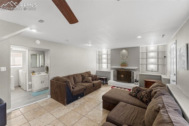 tiled living room with built in shelves, a textured ceiling, and washer / clothes dryer