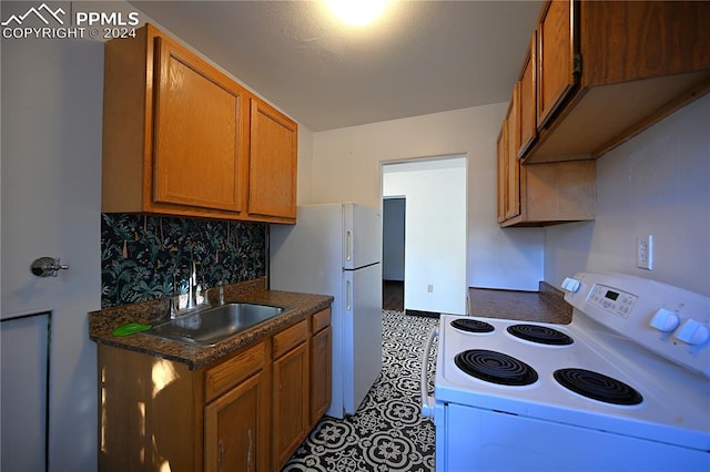 kitchen featuring decorative backsplash, white appliances, and sink