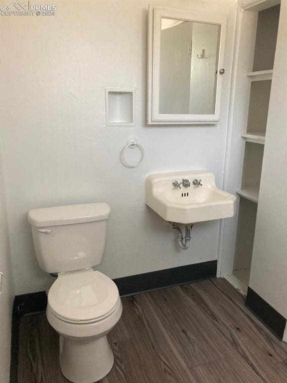 bathroom with hardwood / wood-style floors, toilet, and sink