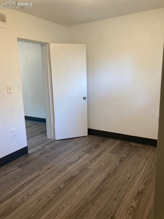 spare room with dark wood-type flooring