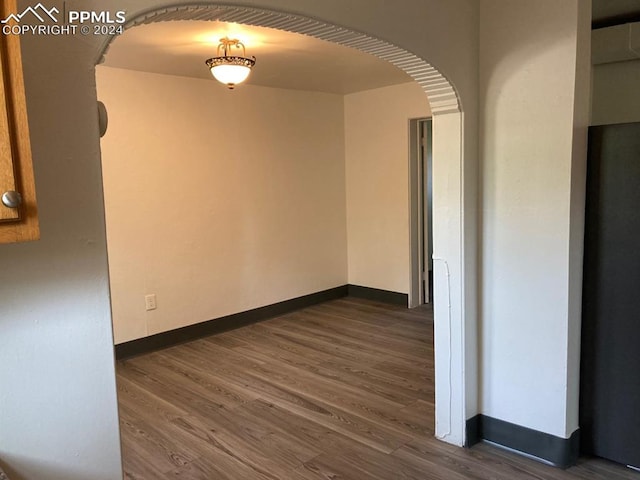 unfurnished room featuring dark wood-type flooring