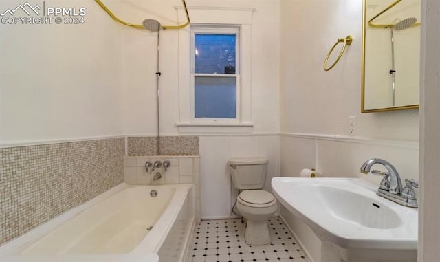 bathroom featuring toilet, sink, and tile walls