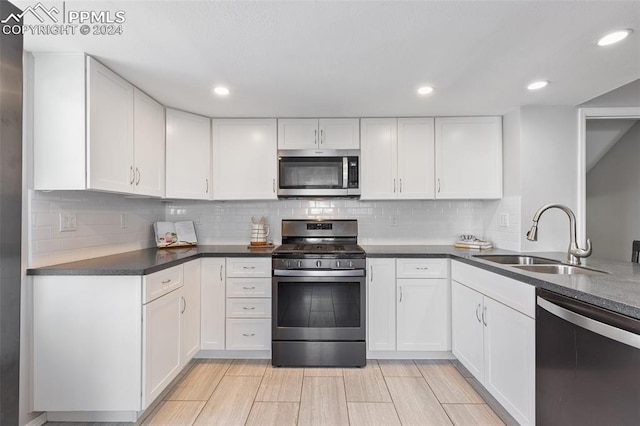 kitchen with sink, white cabinets, and stainless steel appliances