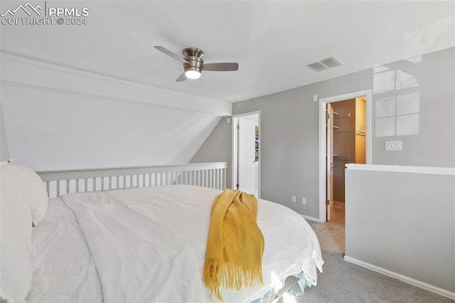 bedroom with a walk in closet, ceiling fan, a closet, and light colored carpet