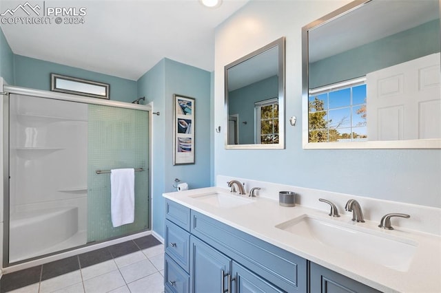 bathroom with tile patterned floors, vanity, and a shower with door