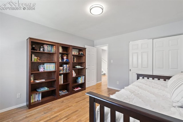 bedroom with hardwood / wood-style floors and a closet